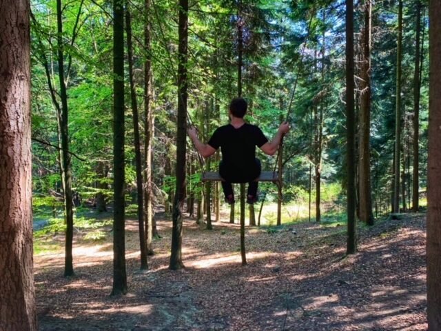 Man in the woods enjoying the power of solitude on a swing